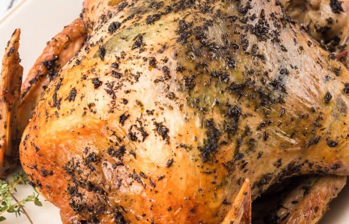 A roasted turkey covered in fresh herbs with sage under the skin.