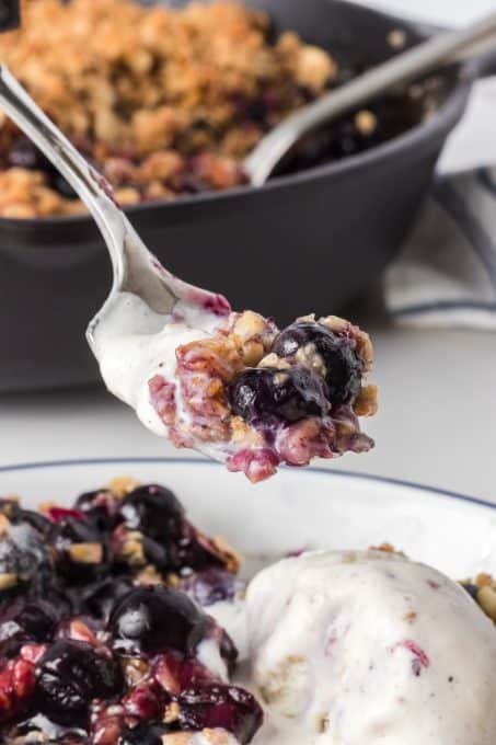 A bite of blueberry crisp made in the skillet.