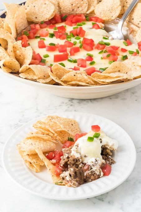 A cheesy dip made with taco seasoned ground beef and refried beans.