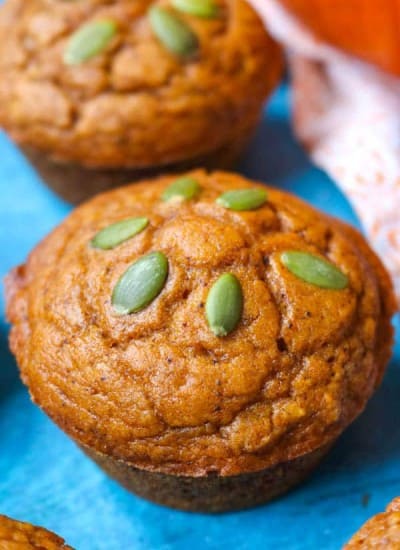 A Dairy-Free Pumpkin Muffin topped with pepitas.