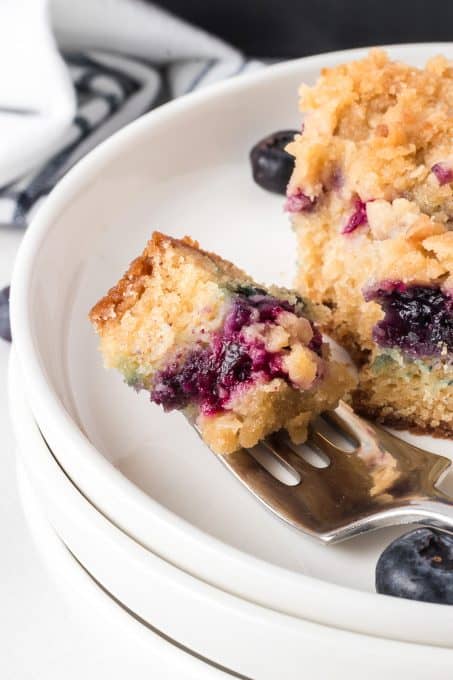 A bite of a crumb cake with blueberries.