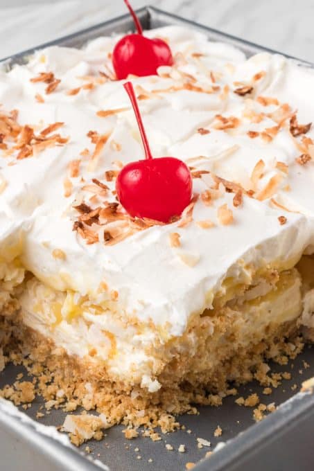 Cool Whip, coconut, pineapple, and cheesecake make these no bake bars.