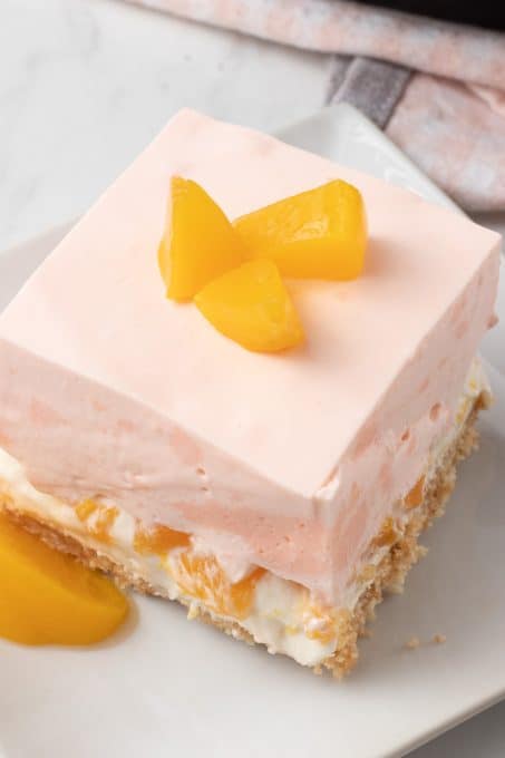 A light no bake peach dessert with a cookie crust, cheesecake and creamy peach gelatin layer.