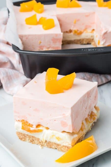 A creamy peach gelatin layer, cheesecake and cookie crust in a no bake summer dessert.