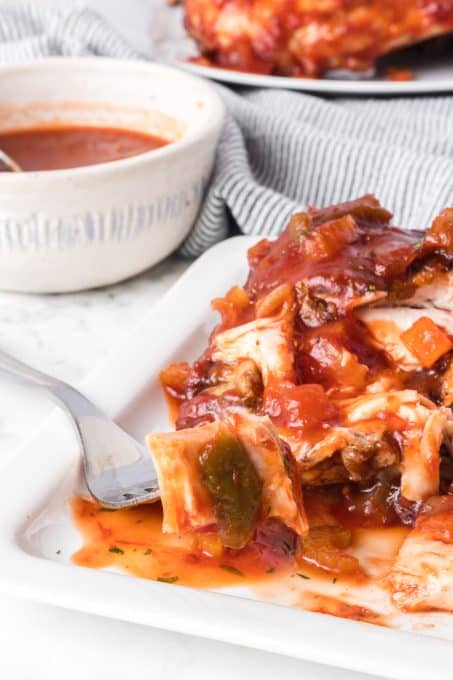 A bite of cooked chicken on the grill basted with homemade barbecue sauce.