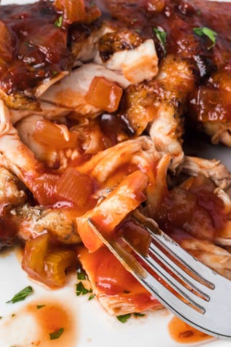 A bite of chicken with a homemade vinegar barbecue sauce.