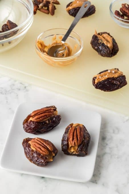 Pecan halves on dates filled with peanut butter.