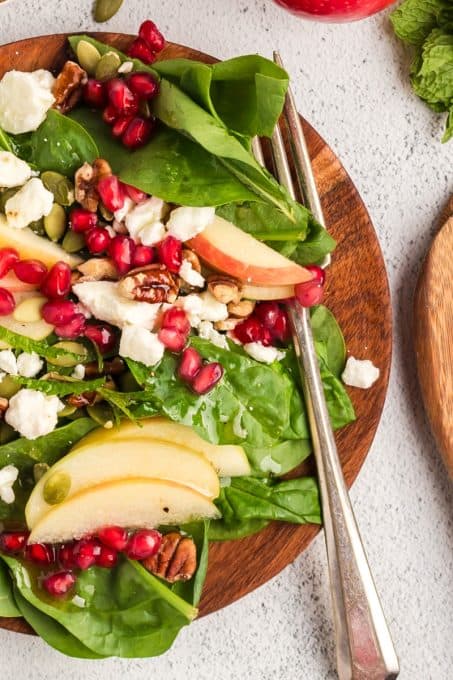 An apple spinach salad with all the finxings.