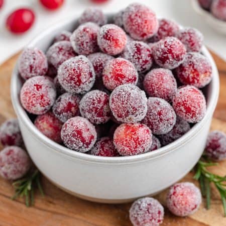 A bowl of cranberries coated in a simple syrup and rolled in sugar.